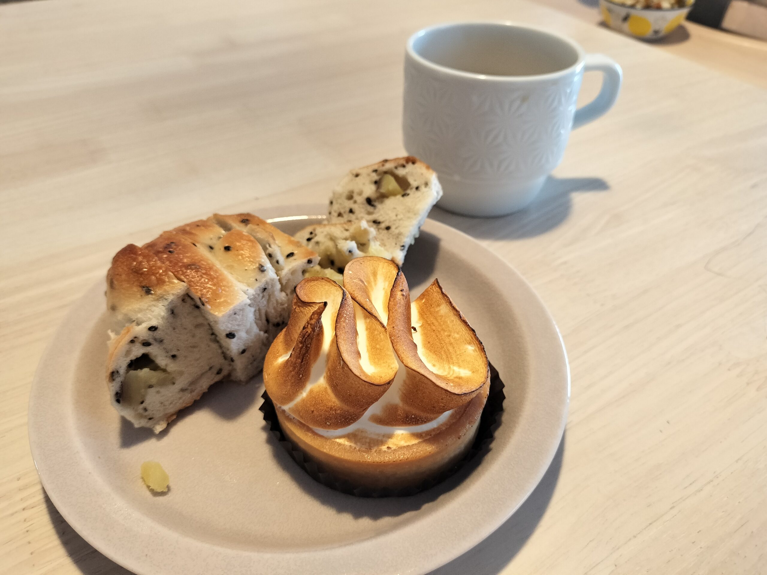 さつまいもとごまのベーグルとレモンタルト、白いマグカップの写真。ある日の朝食